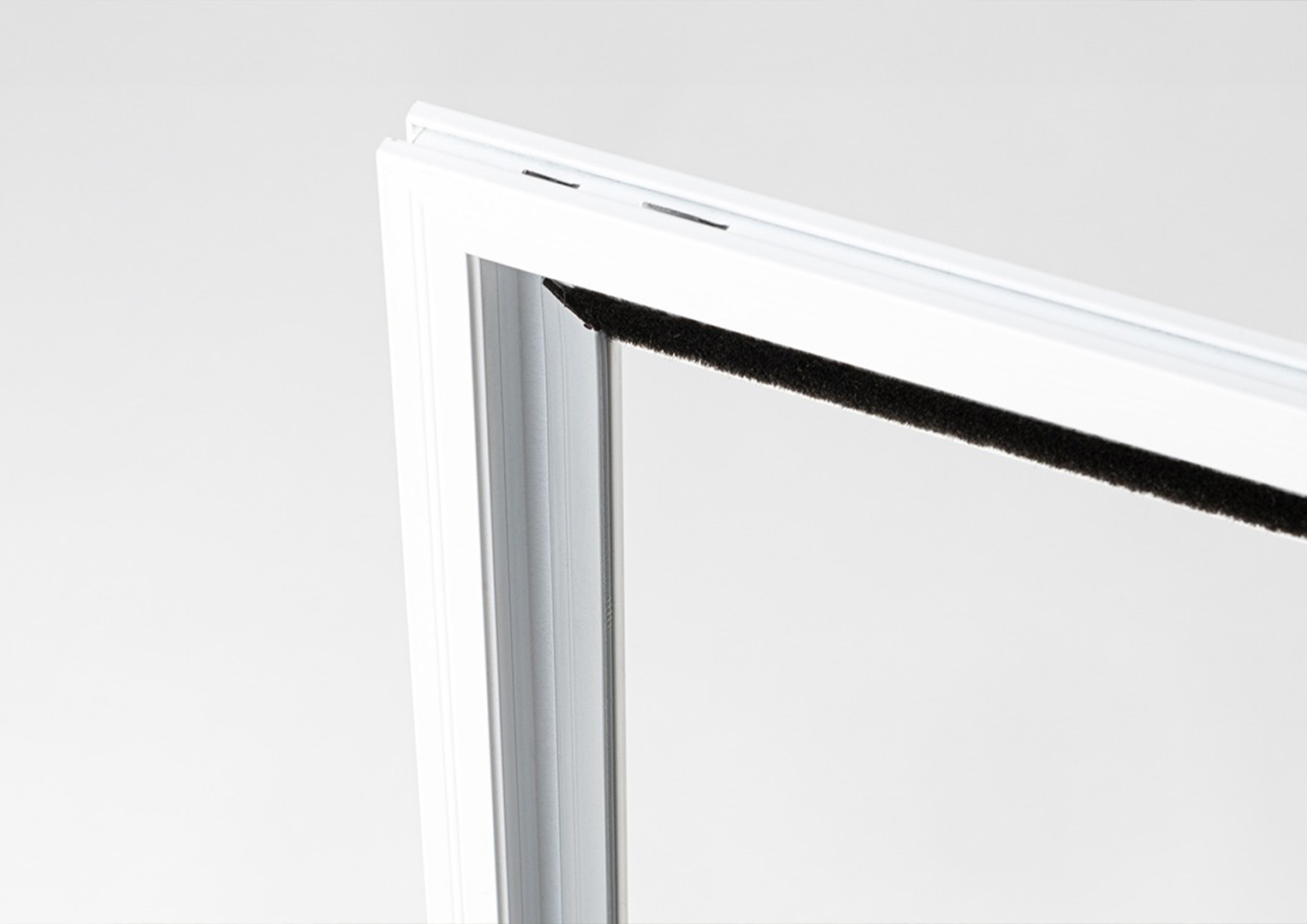 Obere Ecke eines weißen Insektenschutzrahmens mit Bürstendichtung